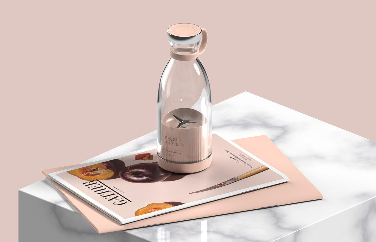 Pink portable blender with clear bottle, ring handle and visible blade assembly