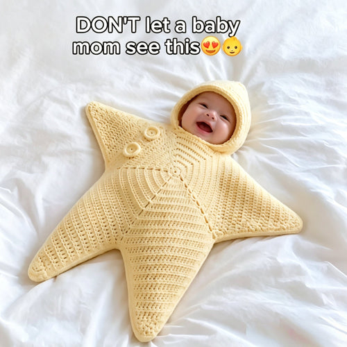 Baby pictured in a pale yellow hooded star-shaped crochet outfit with button detailing