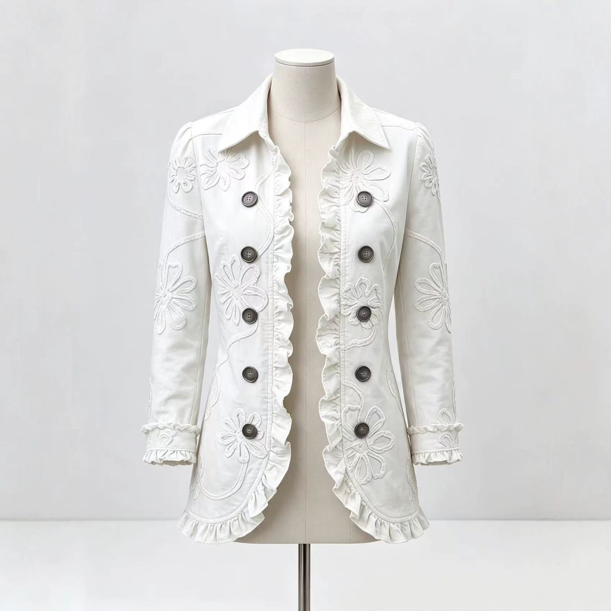 White collared jacket on a mannequin with floral detailing and ruffled edges