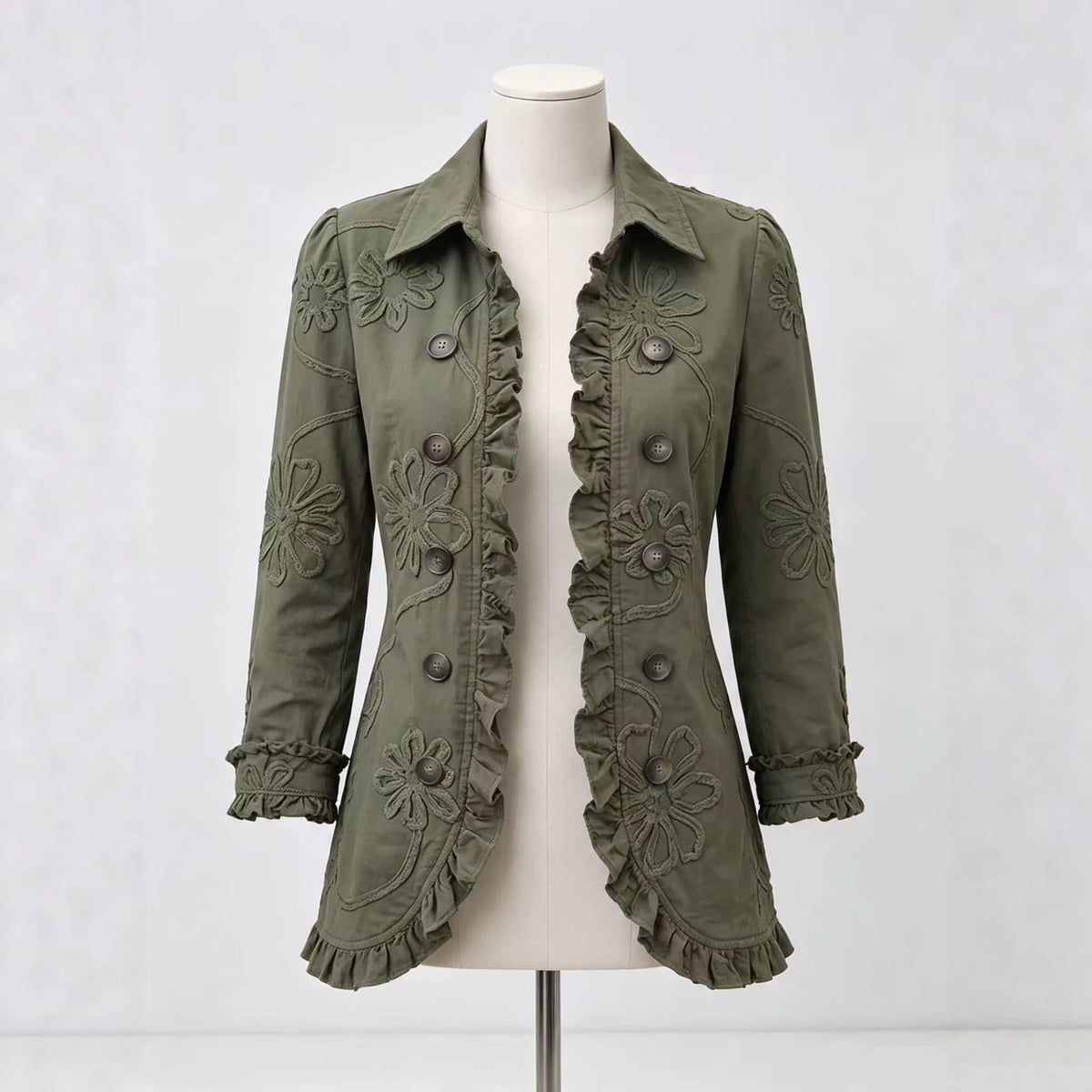 Olive jacket on a mannequin showing floral detailing and decorative buttons