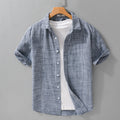 Gray-blue short-sleeve button-front shirt on a hanger over a white T-shirt