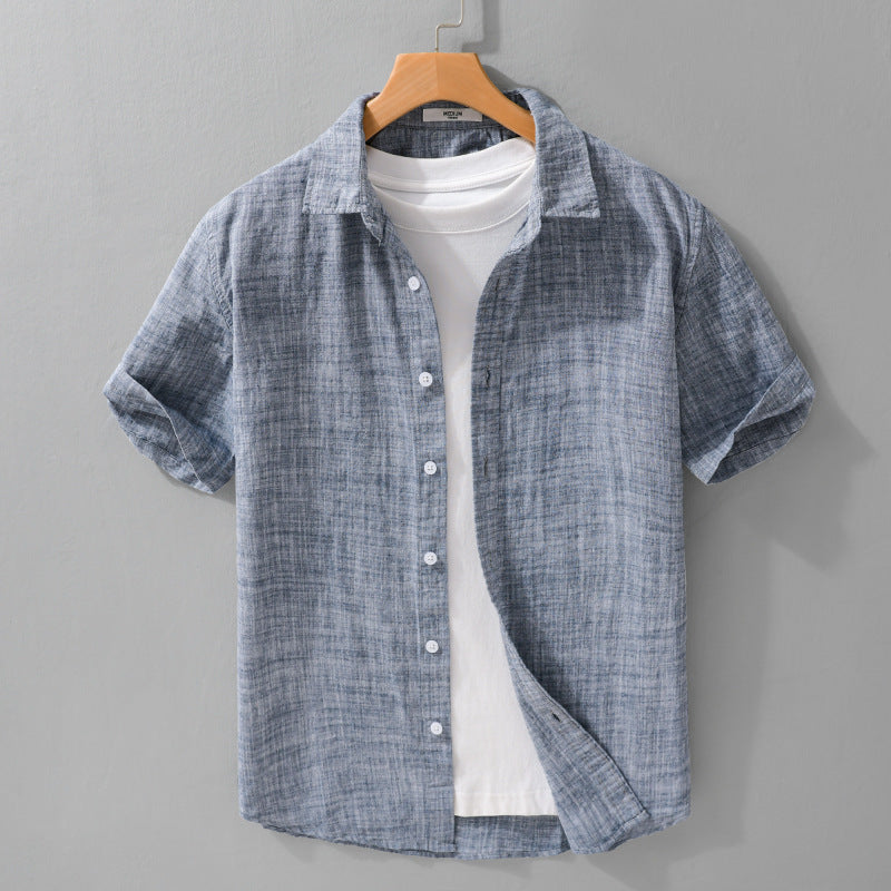 Gray-blue short-sleeve button-front shirt on a hanger over a white T-shirt