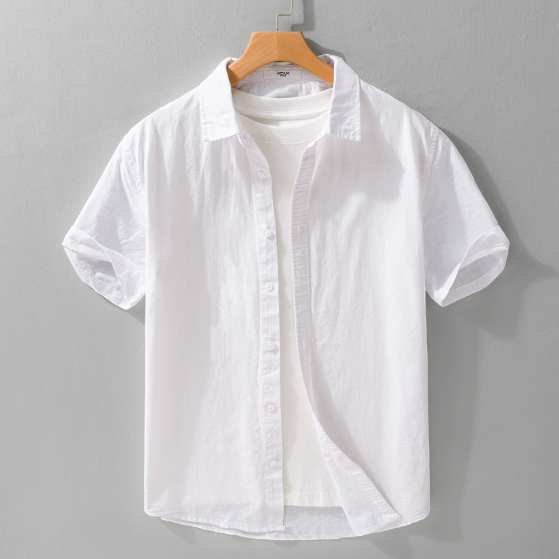 White short-sleeve collared shirt on a hanger over a white T-shirt