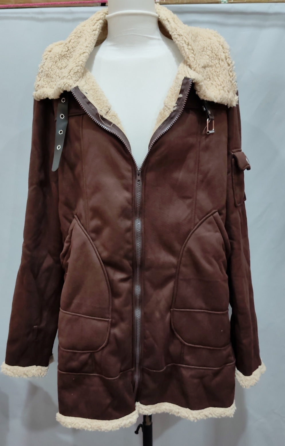 Brown winter jacket on a mannequin showing zip front, broad collar and pockets