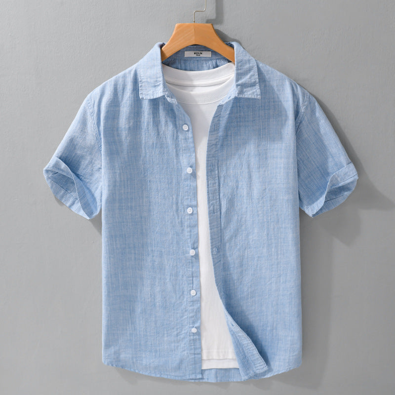 Light blue short-sleeve button-front shirt on a hanger over a white T-shirt