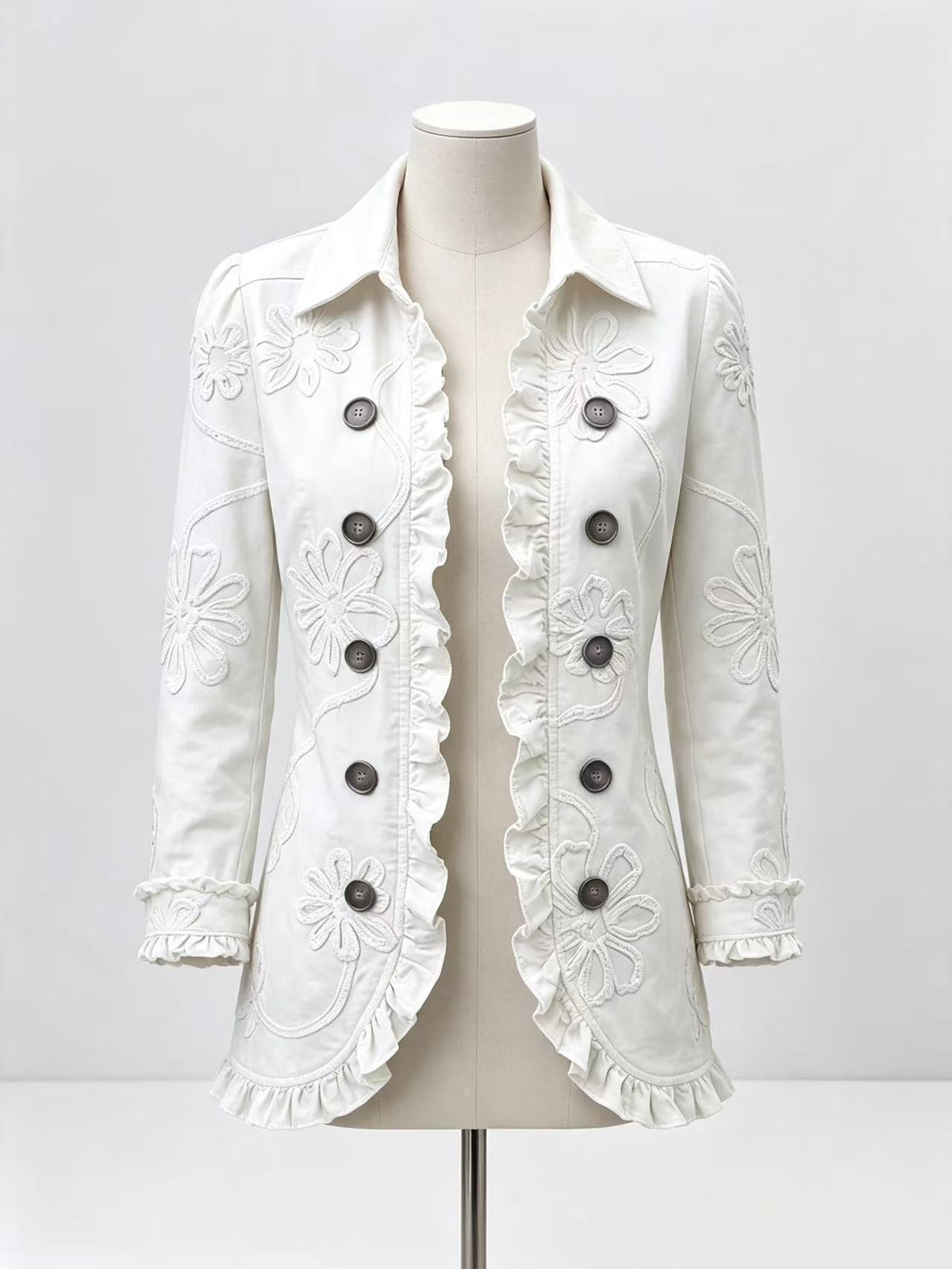 White floral-detail jacket on a mannequin showing ruffled hem and cuffs