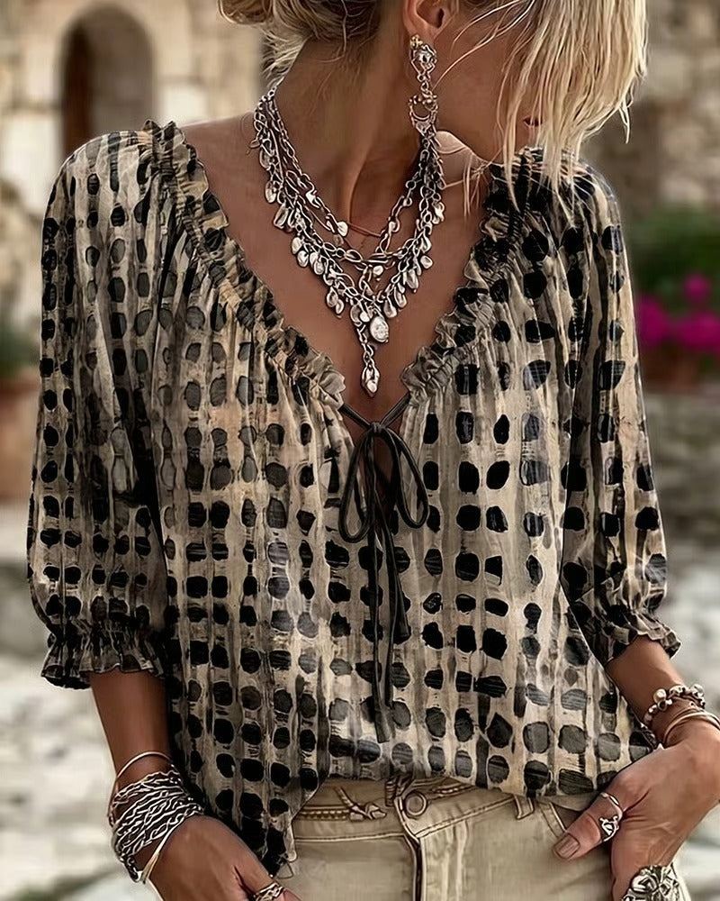 Black and beige printed blouse with ruffled neckline and front tie