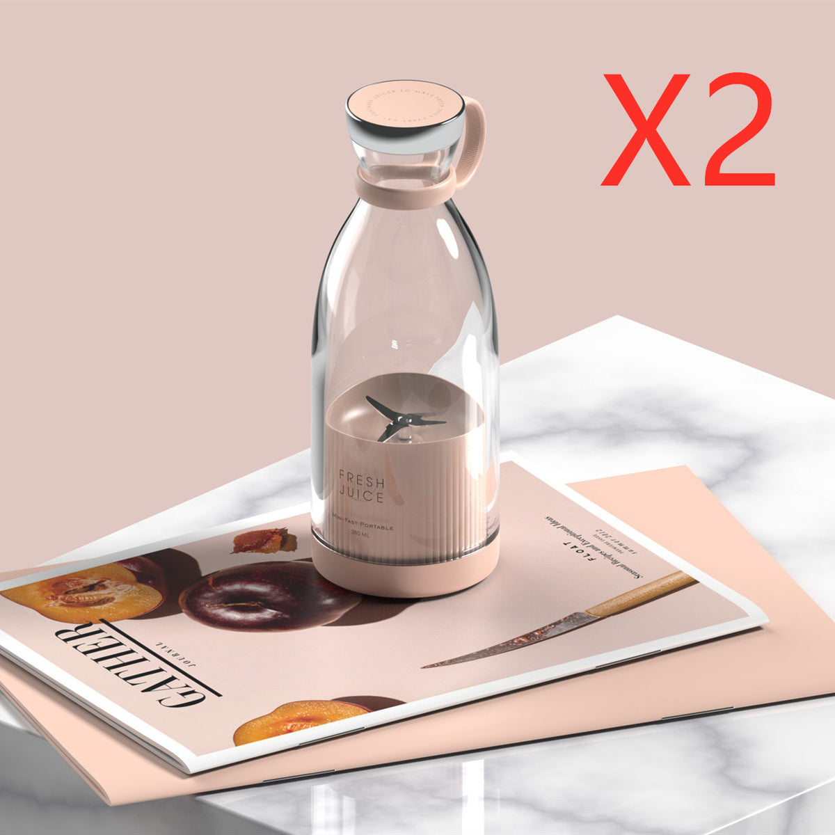 Pink portable blender on a magazine with an X2 label