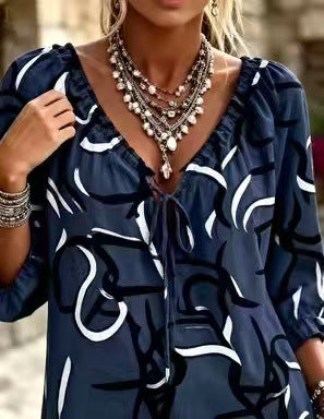 Dark blue blouse with abstract black and white print and tie neckline