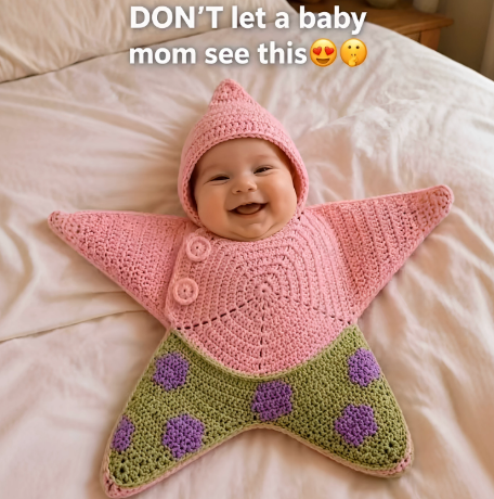 Baby pictured in a pink and green star-shaped crochet outfit with purple flower details