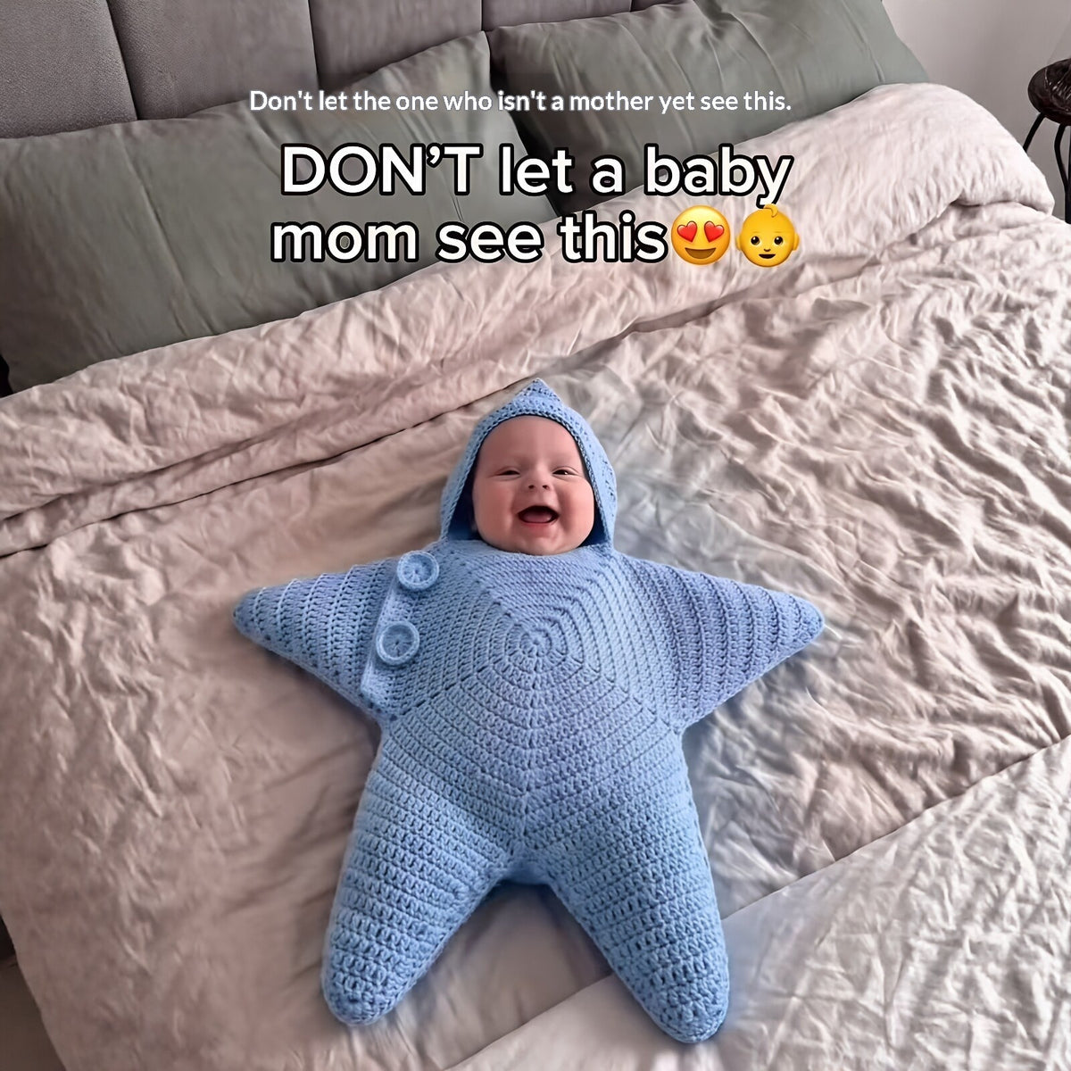 Blue hooded star-shaped crochet outfit with button detailing pictured on a baby