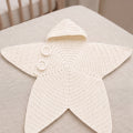 White star-shaped crochet outfit laid flat on bedding